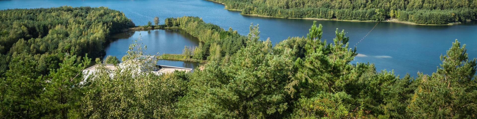 A lake surrounded by dense forests and hills.