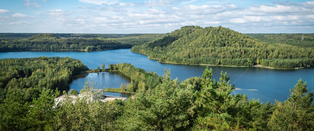 A lake surrounded by dense forests and hills.
