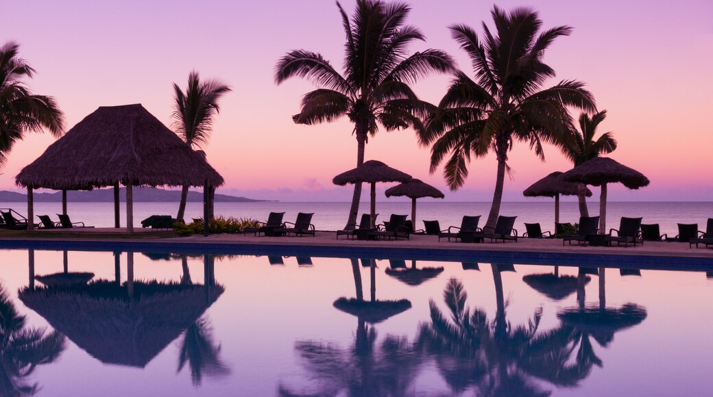 Pinkish purple sunrise colors reflecting in the water in Fiji