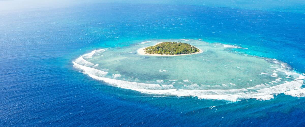 An aerial view of a small island surrounded by turquoise waters.