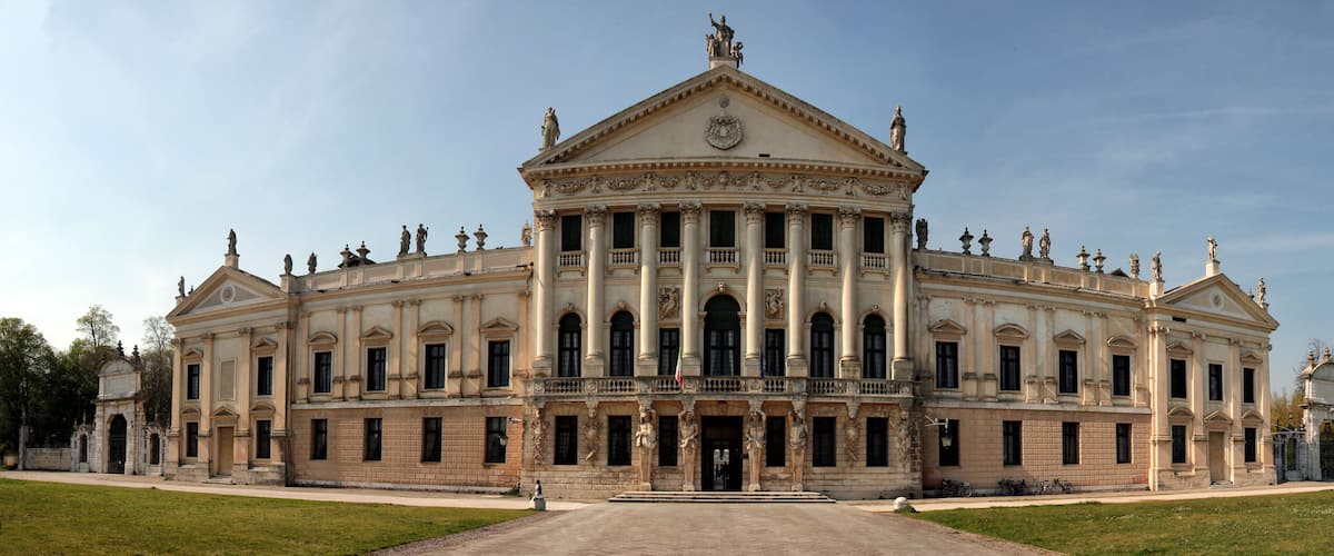 A grand neoclassical building with a symmetrical facade, large columns, and statues.