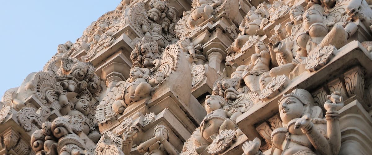 A detailed stone facade with intricate carvings of figures and floral patterns.