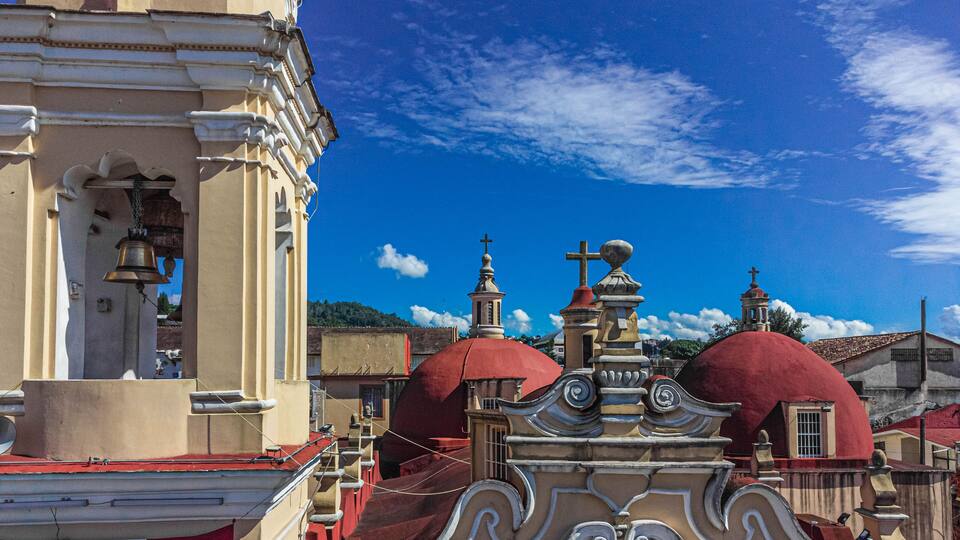 A church with red domes and a bell tower.