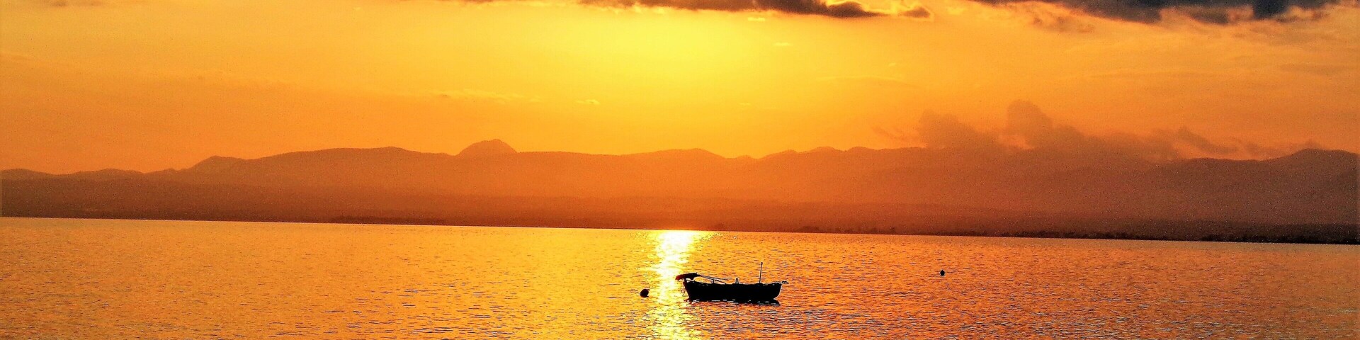 I took this photo from the seaside village of Paralia Vergas, near Kalamata, Greece. Beautiful golden memories of last Summer! Paralia Vergas is just a few KM from Kalamata and is one of the best spots in the area to relax and gaze at the sea and mountains. Especially at sunset! And here in this scene I love how peaceful and calm it is. And the boat makes it idyllic!