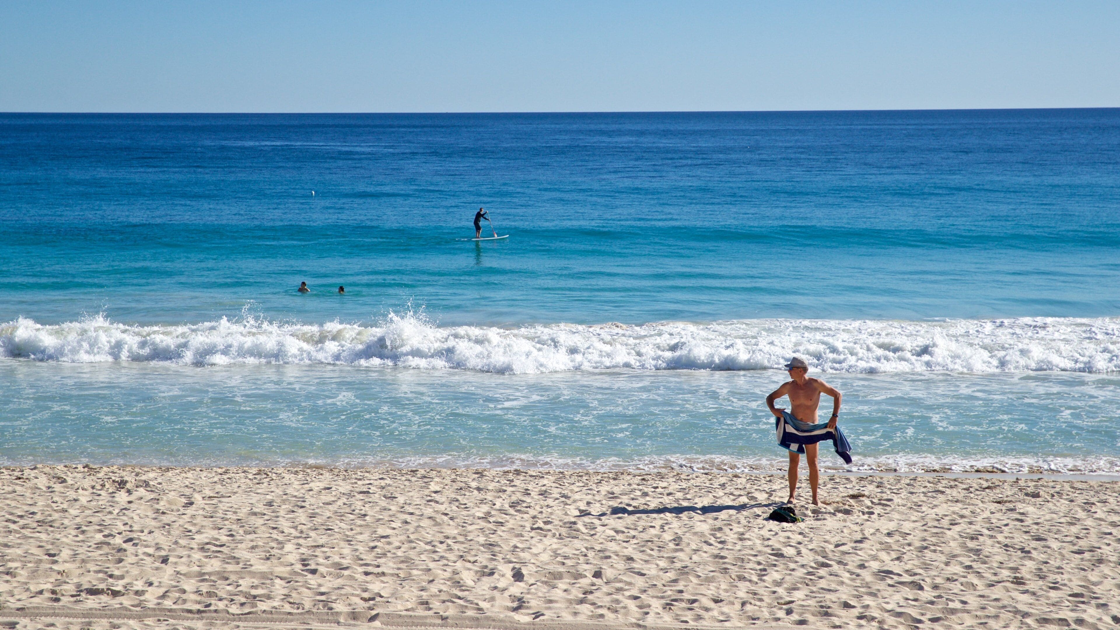 Scarborough Beach which includes general coastal views and a sandy beach as well as an individual male