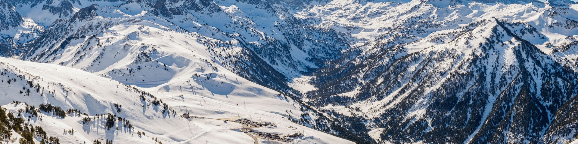 A snow-covered mountain range with ski slopes and a ski resort.