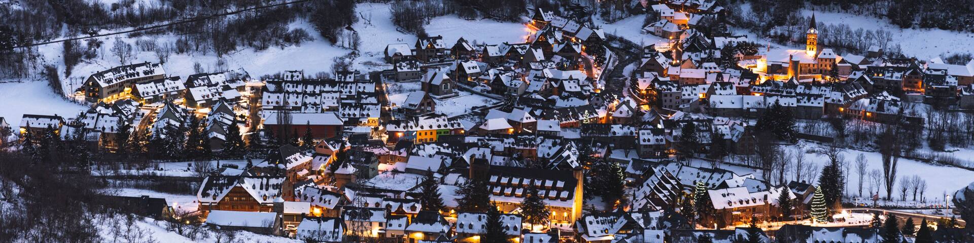 Spain, Cataluna, Baqueira, Ski resort covered with snow illuminated at dusk