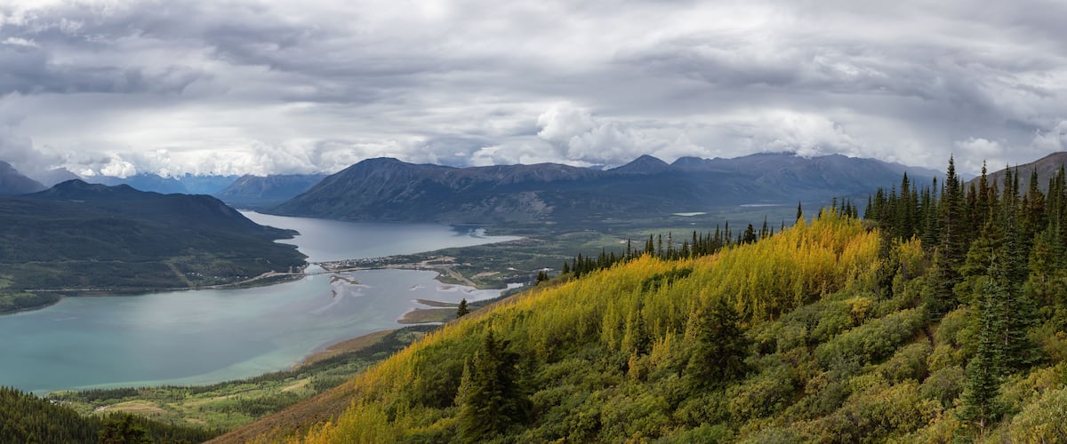 A lake surrounded by mountains and dense forests.