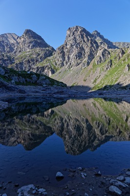 A mountain landscape with a clear reflection in a calm body of water.