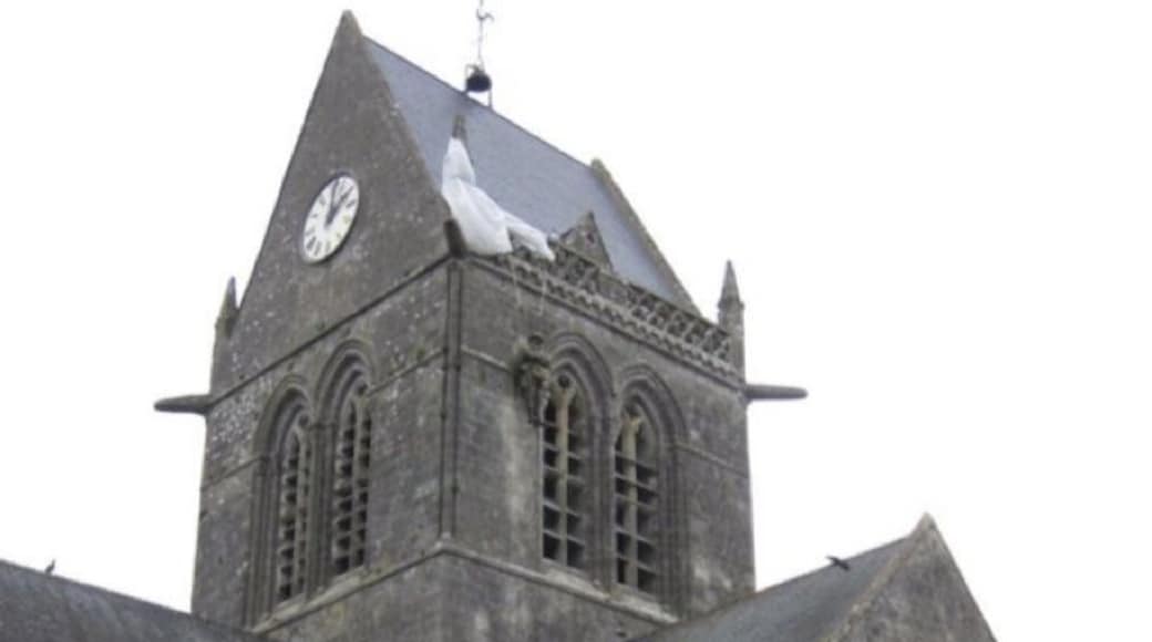 On D-Day, John M.Steele, one of the mortar platoon of the 505 PIR of the US 82nd Airborne had his chute snag on the church tower as he descended. Here he hung during the battle, watching helplessly as his colleagues fought below. This scene was famously reenacted in the film "The Longest Day", and a manequin now hangs from the church in Ste Mere Eglise depicting the event (do you see him?)