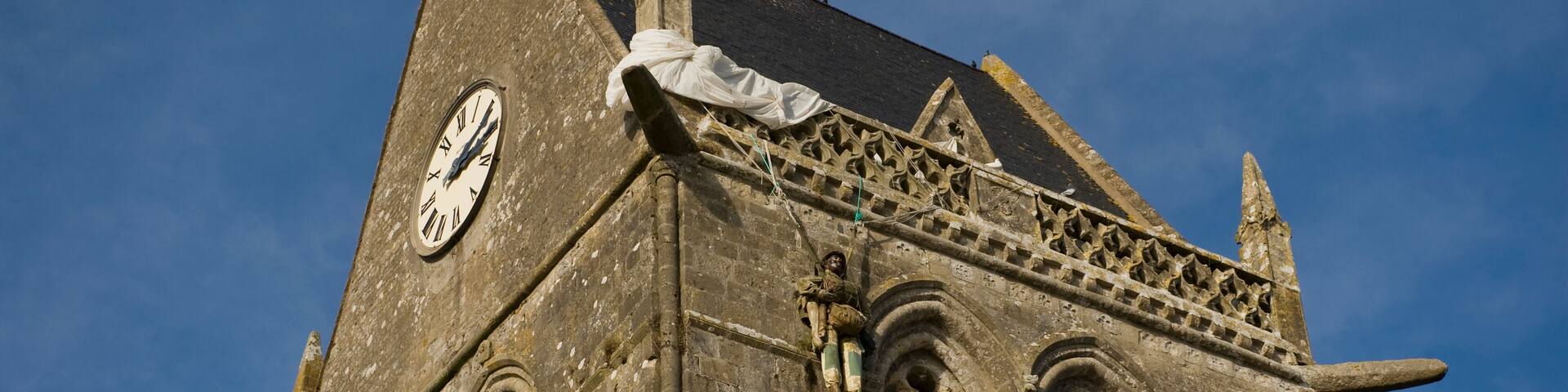 Close up of the top of a cathedral in Sainte-Mere-Eglise, France. This is where a paratrooper got caught up on the steeple during the D-Day Invasion in 1944; Sainte-Mere-Eglise, Normandy, France