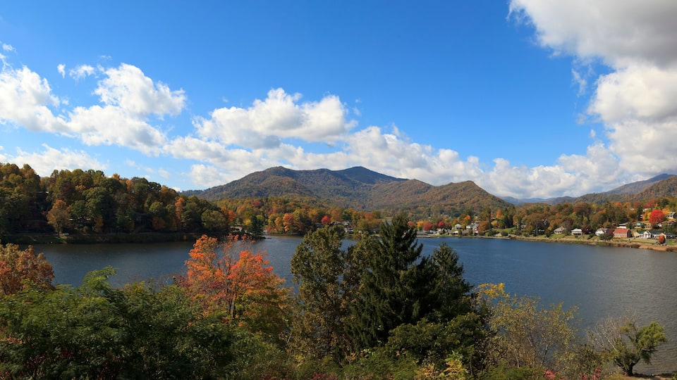 A lake surrounded by autumn-colored trees and mountains.