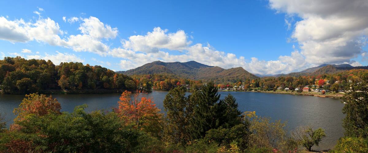A lake surrounded by autumn-colored trees and mountains.