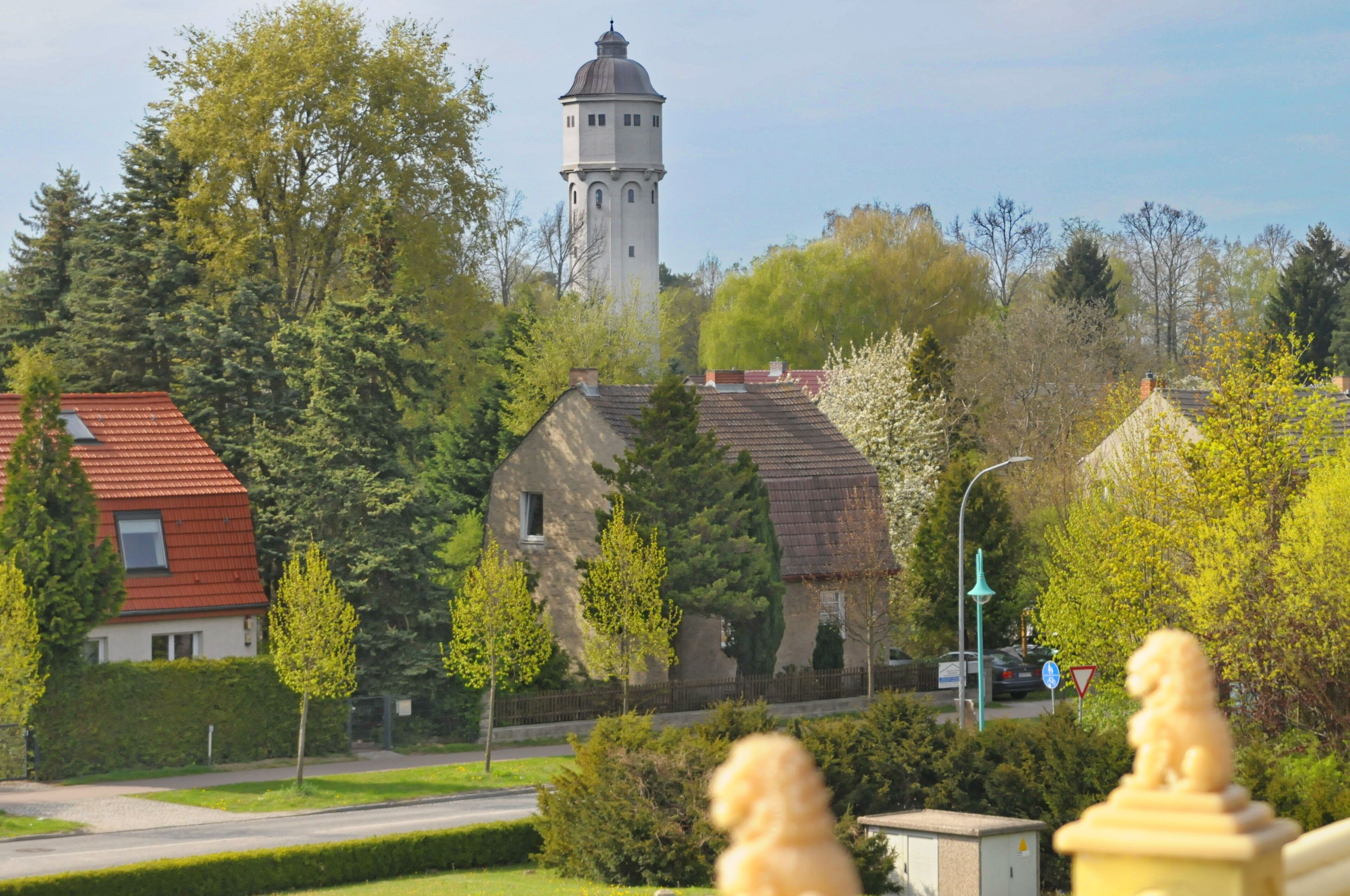 A tower, houses, trees, and a statue.