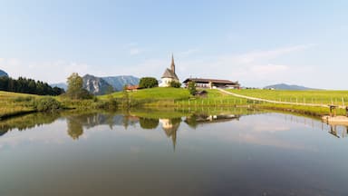 Inzell, Germany - August 5, 2018: View of the Nikolauskirche church in the Bavarian community of Inzell with the Alps in the background.