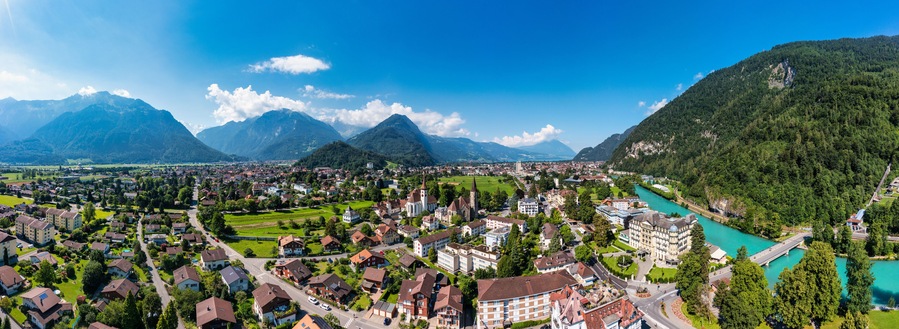 Une ville nichée entre des montagnes, traversée par une rivière.