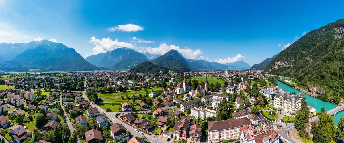 A town nestled between mountains with a river.