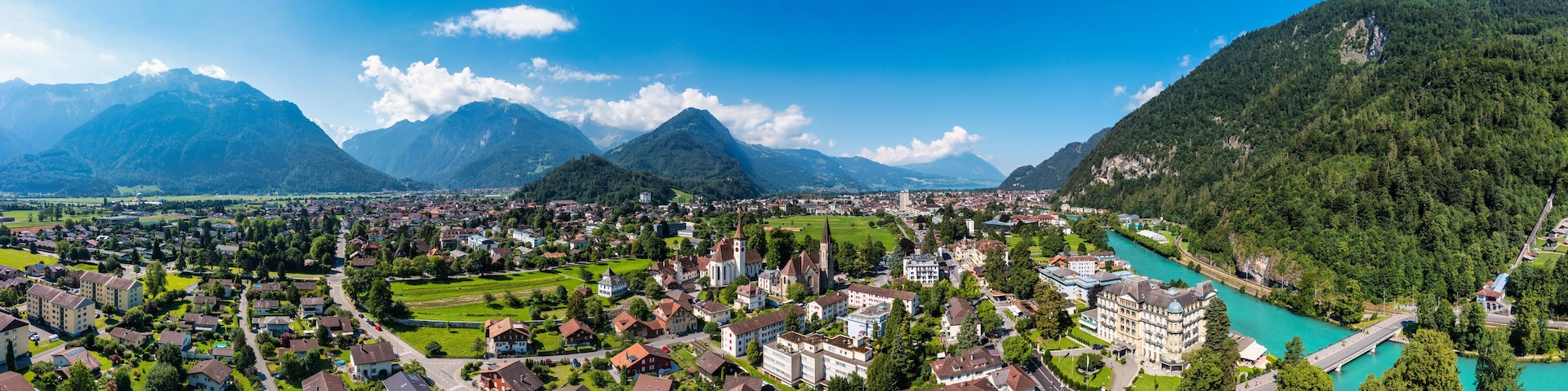 A town nestled between mountains with a river.
