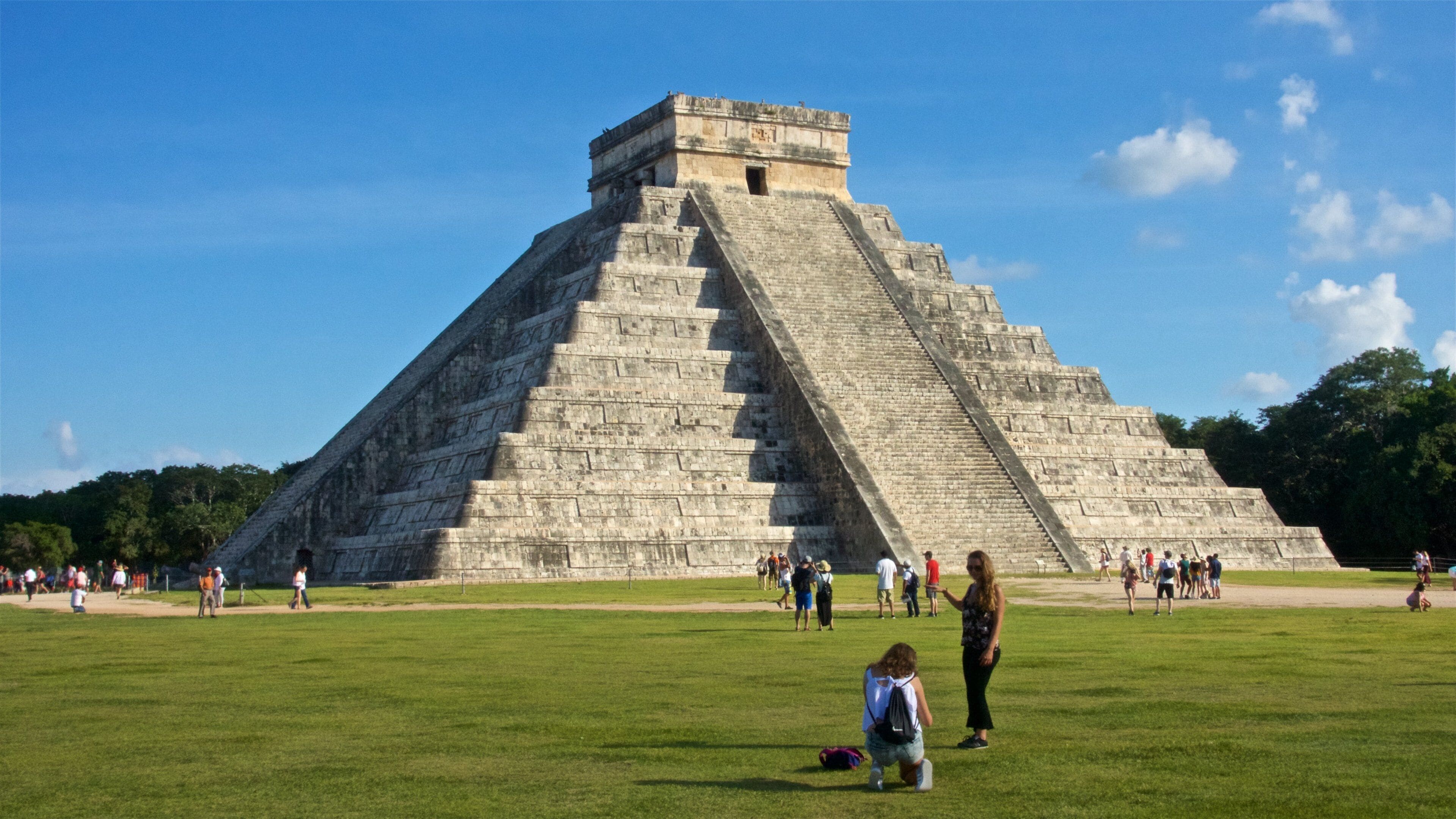 Una pirámide grande con turistas alrededor.