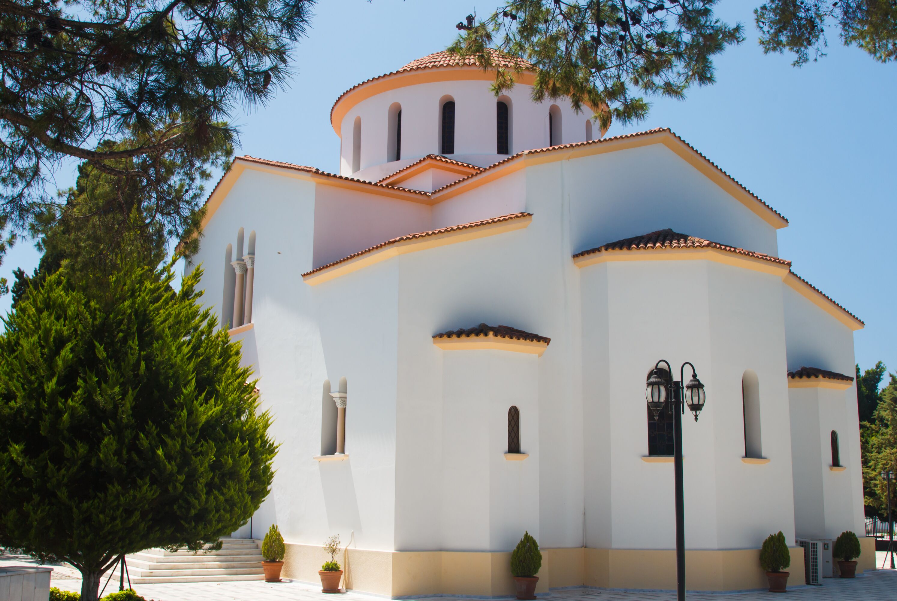 A white building with a tiled roof and arched windows.