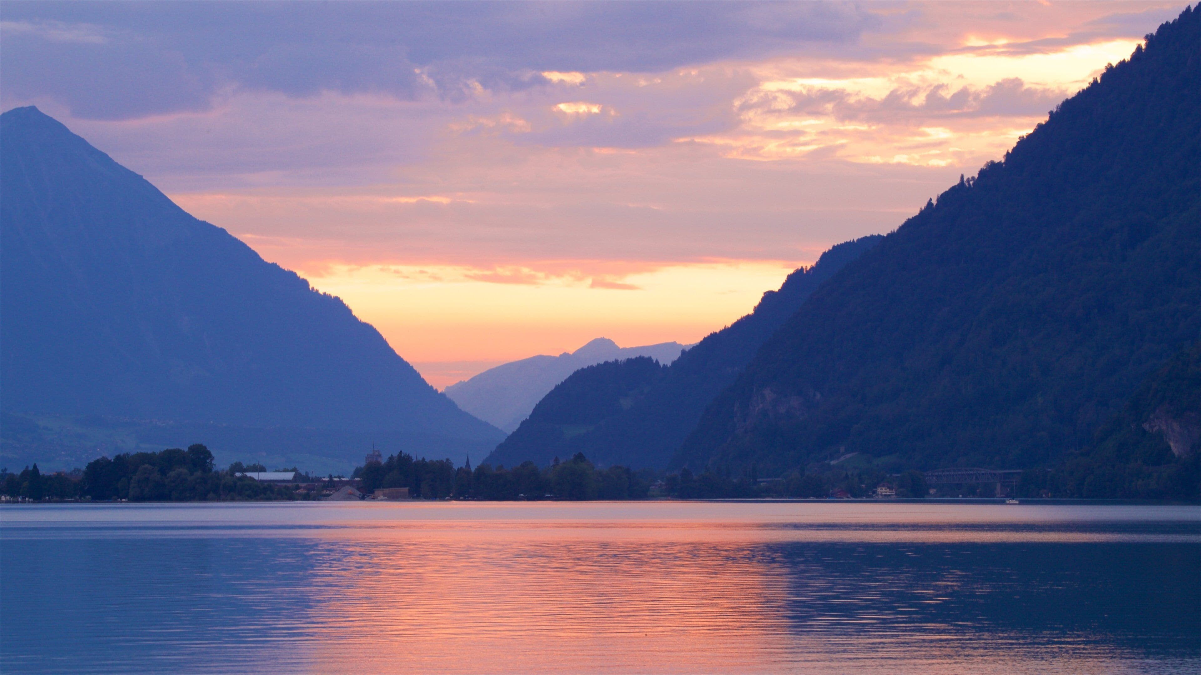 Interlaken which includes a lake or waterhole, a sunset and mountains