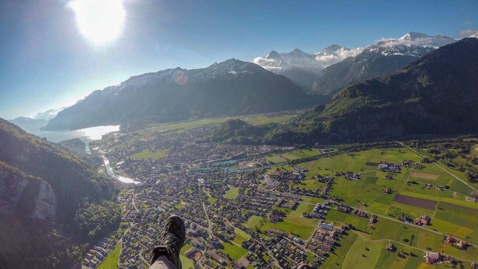 A mountainous landscape with a valley, a lake, and a town below.