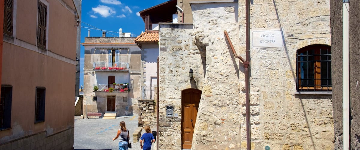 A narrow street with stone buildings, a sign reading "VICOLO STORTO", and a wooden door.