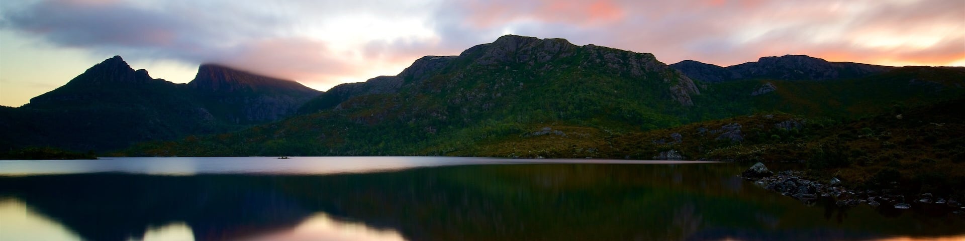 A mountain range with a lake reflecting the sky.