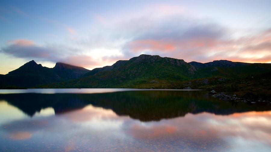 Uma cordilheira com um lago refletindo o céu.