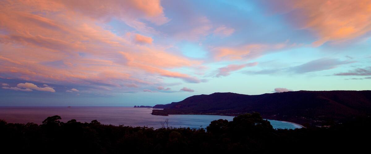 Tasman Peninsula showing a sunset, a bay or harbor and general coastal views