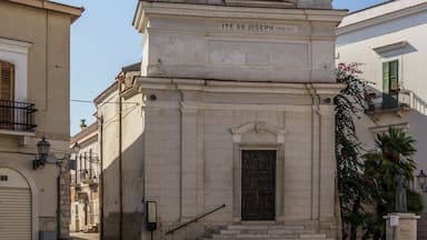 Uma igreja histórica com um campanário e uma estátua no topo.