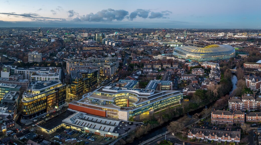 Een stadsgezicht met een opvallend stadion, woonwijken en industriële gebouwen.
