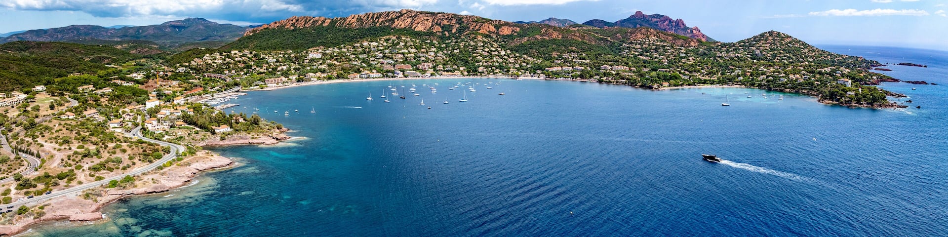 A coastal town with a bay, boats, and mountainous terrain.