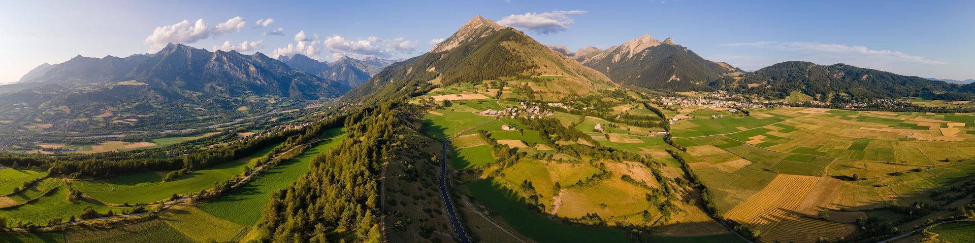 Panoramic aerial view of villages of Les Faix (center), Ancelle (right) and Saint-Leger-les-Melezes (left). Summer in Champsaur Valley, Hautes Alpes (Alps), France