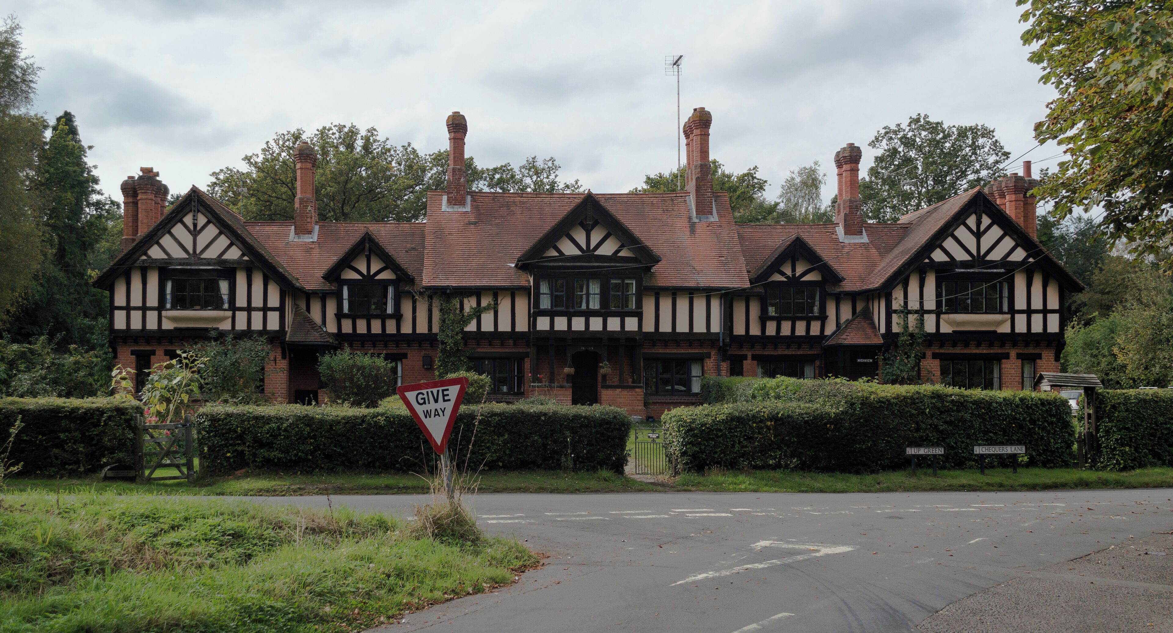 A Tudor-style building with a 'Give Way' sign in front.