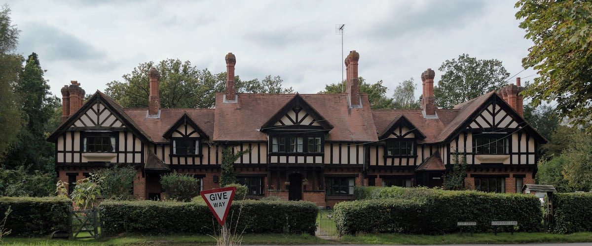A Tudor-style building with a 'Give Way' sign in front.
