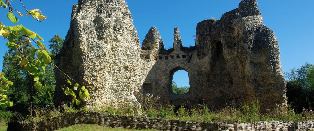 A stone ruin with a large archway and a tall, pointed structure.