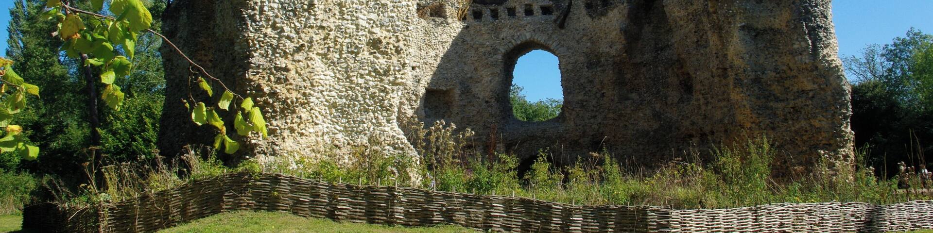 A stone ruin with a large archway and a tall, pointed structure.