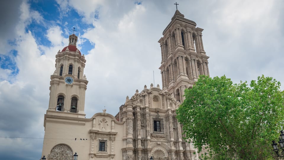 A historic church with a bell tower and a prominent cross.