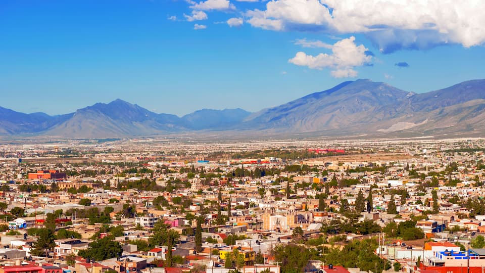A cityscape with mountains in the background.