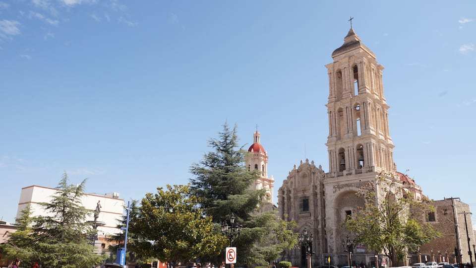 A historic cathedral with a red dome and a bell tower.
