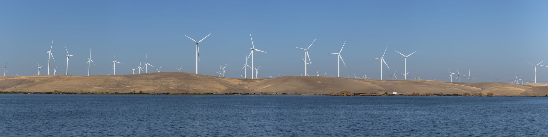 Wind turbines renewable energy off the water in Rio Vista Ca. on a clear day