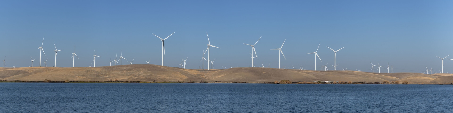 Wind turbines renewable energy off the water in Rio Vista Ca. on a clear day