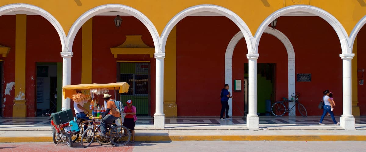 A yellow building with white arches and a coat of arms.