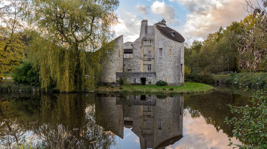 MONTMORENCY, FRANCE - NOVEMBER 10, 2013: The hunting Castle ("Château de la chasse" in french) reflecting on a pond at sunset, located in the Montmorency Forest.