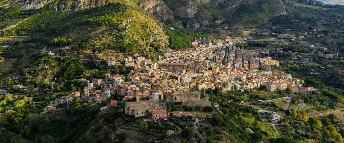A town nestled in a valley with mountains in the background.