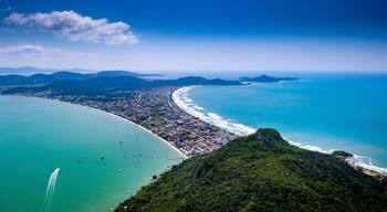 Eine Küstenstadt mit einem langen Strand, dicht bebauten Stadtgebiet und umgebenden Bergen.