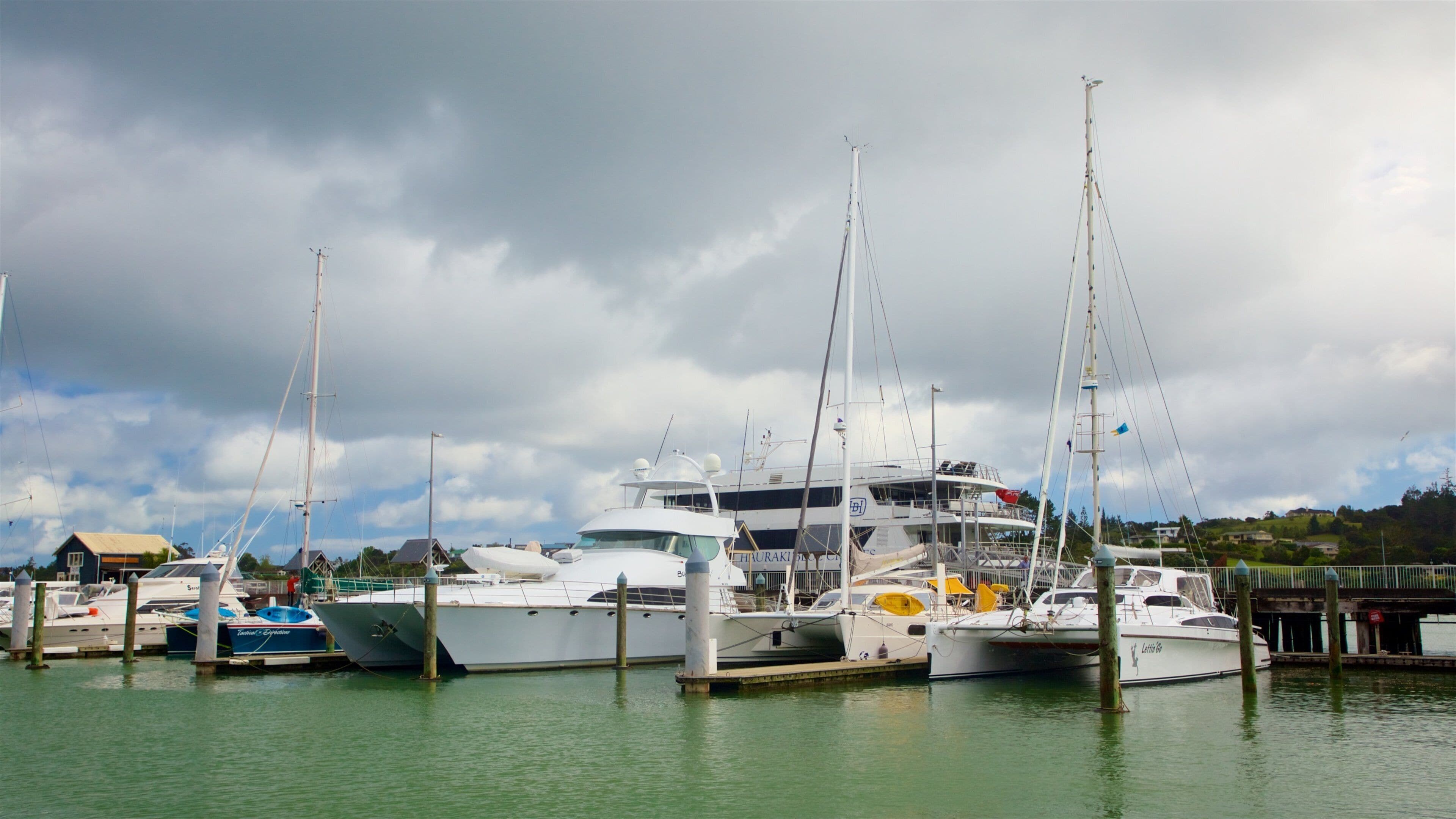A marina with several sailboats docked at wooden piers.