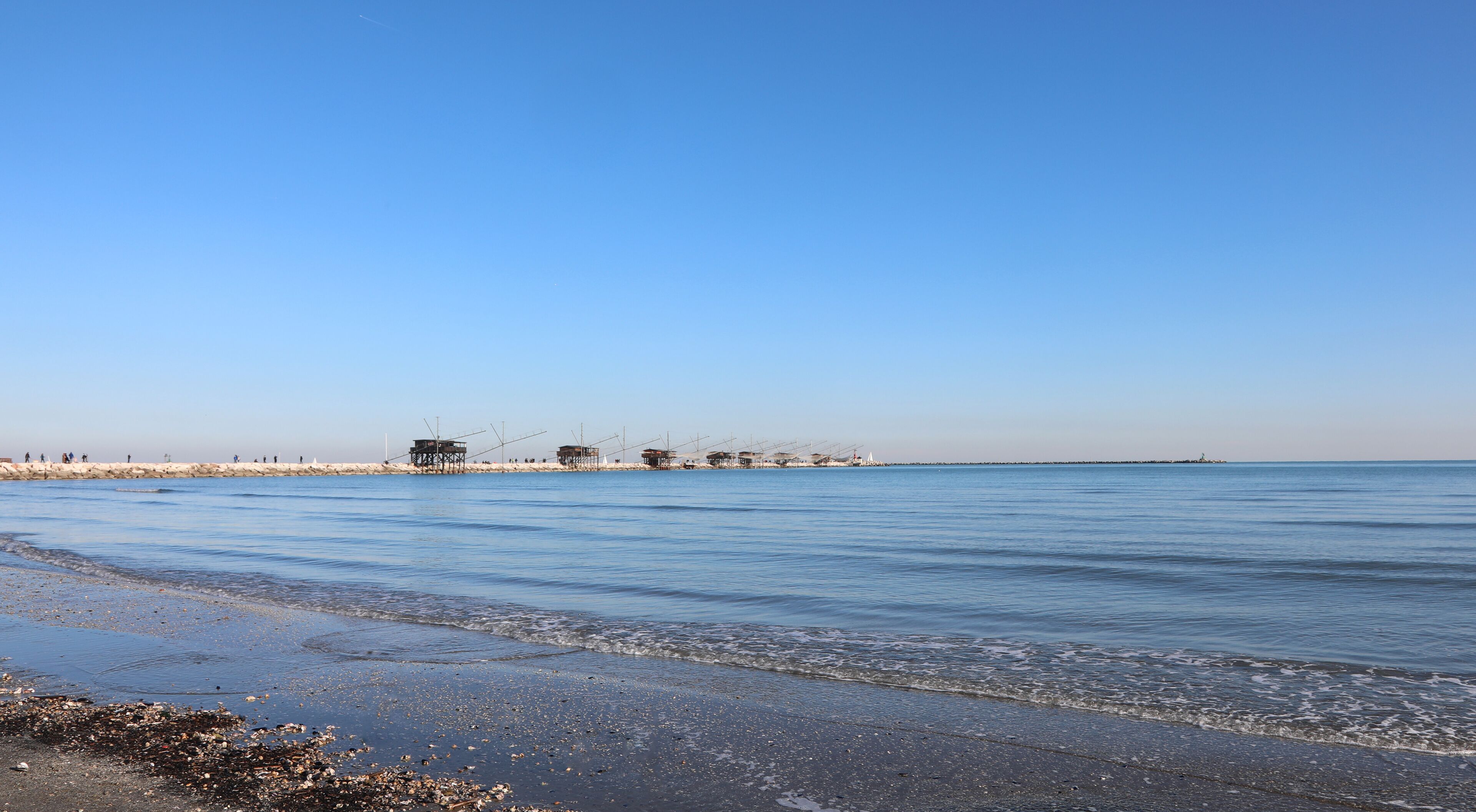 shore of the beach at low tide and the wooden houses called Trabucchi in the Italian language