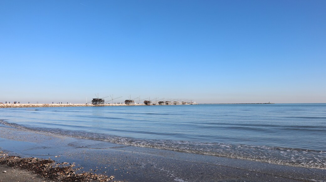 shore of the beach at low tide and the wooden houses called Trabucchi in the Italian language